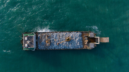 A ship is carrying a backhoe in the sea.