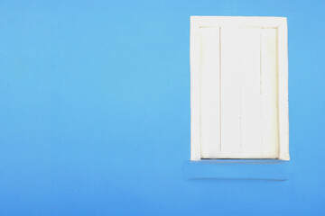 Fachada antiga azul com janela branca