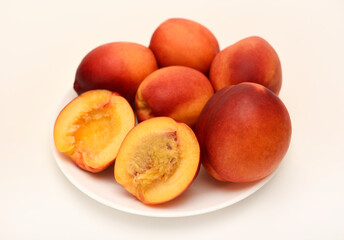 Ripe peaches on a white plate. Juicy fruits.