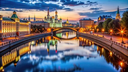 Obraz premium Vibrant evening scene of Moscow's canal, lined with majestic buildings, ornate bridges, and colorful streetlights, reflecting beautifully in the calm water's mirrored surface.