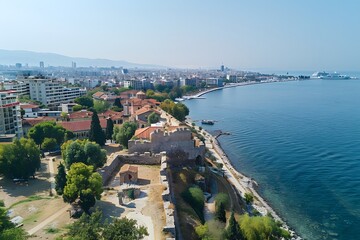 Obraz premium Aerial View of Coastal City with Historic Fortifications and Modern Skyline