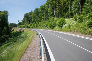 Fototapeta premium Road with asphalt coating. Heavy and light vehicle movement a road among the mountains. Paved road for car traffic, construction of a new paved road for transport in rural areas