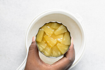 Overhead view of canned pineapple chunks, top view of pineapple pieces in a can