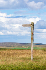 A wooden signpost showing a public bridleway to Carrshield at an altitude of 550 metres on Carrshield Moor near Coalcleugh, Northumberland, England UK