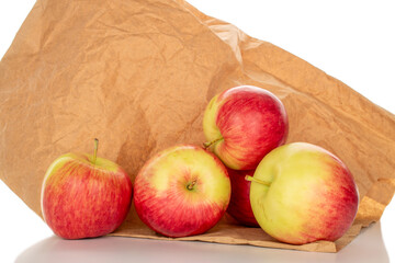 Several red apples on a paper bag, macro, isolated on a white background.