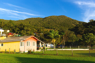 Charming countryside cottage with lush green surroundings, nestled beneath a tranquil hill