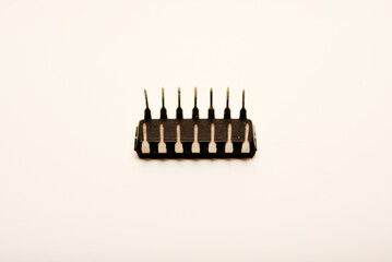An old chip on a white background. The chip is in a DIP case. An integrated circuit.
