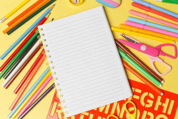 Back to school concept with variety of office and school supplies on yellow background.	