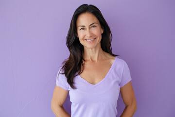 Fototapeta premium An elegant mature woman poses confidently with a smile, complemented by a solid violet background