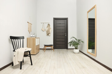 Stylish hallway with big mirror and chest of drawers. Interior design
