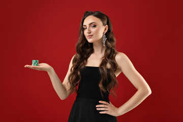 Charming woman with poker chips on red background