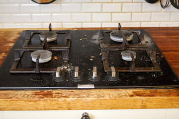 the process of cleaning a black stove in a home kitchen