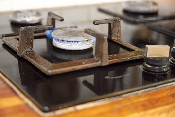 the process of cleaning a black stove in a home kitchen