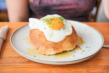 A plate of food with a fried egg on top of a pancake