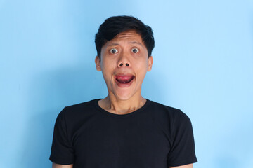 Shocked face of Asian young man in black t-shirt on a isolated background