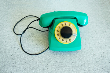 Retro green rotary telephone close-up on a gray background. Place for text