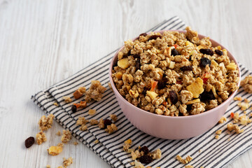 Healthy Homemade Muesli with Fruits in a Pink Bowl, side view. Copy space.