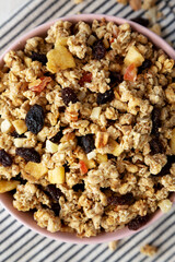 Healthy Homemade Muesli with Fruits in a Pink Bowl, top view.