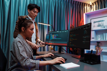 Serious of IT developers discussing intelligent website development coder system running data online two screens with laptop showing information network at neon light room at modern office. Infobahn.