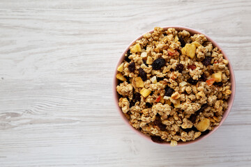 Healthy Homemade Muesli with Fruits in a Pink Bowl, top view. Flat lay, overhead, from above. Copy space.