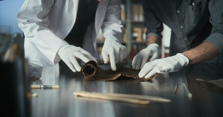 Scientists study cultural heritage of extinct human civilization. Two archaeologists in gloves...