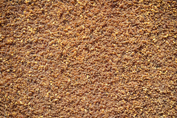 Surface covered with amber crumbs, background.