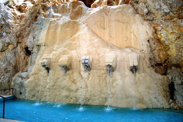 Blue water splashing in thermal baths in the cave, swimming pool, hot springs, relaxation and spa,...