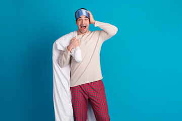 Naklejka premium Photo portrait of attractive young man amazed reaction hold blanket dressed pajama sleepover good night isolated on blue color background