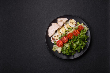 Delicious fresh caesar salad in a bowl with chicken breast, egg, tomatoes