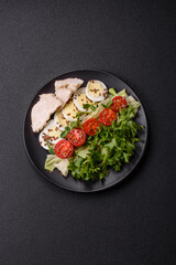 Delicious fresh caesar salad in a bowl with chicken breast, egg, tomatoes