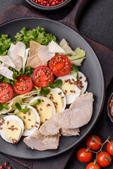 Delicious fresh caesar salad in a bowl with chicken breast, egg, tomatoes