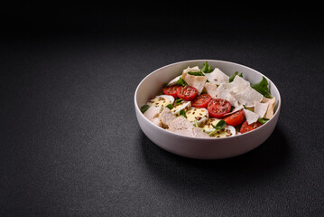 Delicious fresh caesar salad in a bowl with chicken breast, egg, tomatoes