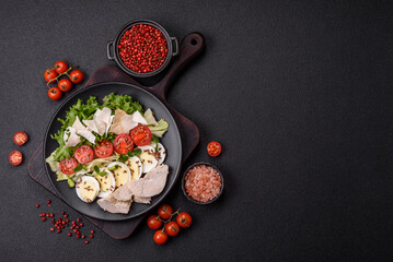 Delicious fresh caesar salad in a bowl with chicken breast, egg, tomatoes
