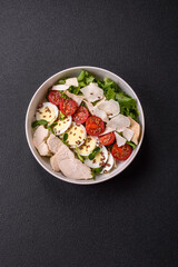 Delicious fresh caesar salad in a bowl with chicken breast, egg, tomatoes