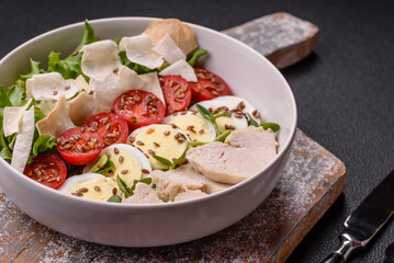 Delicious fresh caesar salad in a bowl with chicken breast, egg, tomatoes