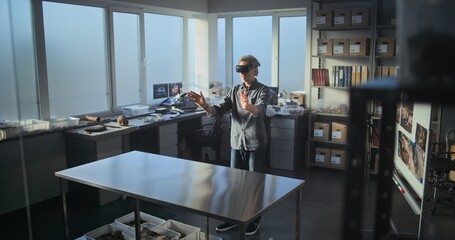 Mature archaeologist or scientist wearing AR headset conducts historical and scientific research in...