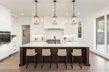 Modern Kitchen Island with White Cabinets and Pendant Lights - A contemporary kitchen island with white cabinets, a dark wood countertop, and four sleek bar stools. The island is illuminated by three 