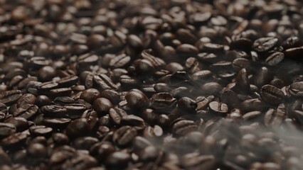 Close up of fresh brown coffee bean with roasted smoke from pile of coffee beans. Macrography of hot coffee seed with fragrant and scented hot smoke come from pile of bean. Top down view. Comestible.