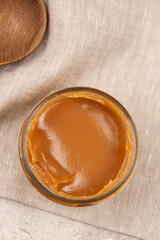 An open jar of homemade caramel, top view, close-up