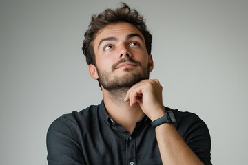 Portrait of a thoughtful man looking up with hand on chin