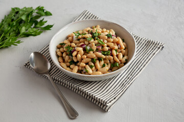 Homemade White Bean Salad with Herbs and Onion in a Bowl, side view.