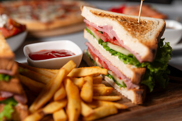 restaurant sandwich with meat and vegetables and with French fries with ketchup