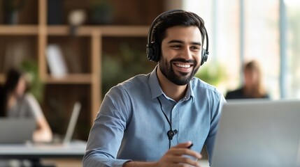 Happy Indian call center agent wearing headset talking to client working in customer support office. Professional contract service telemarketing operator using laptop having conversation.