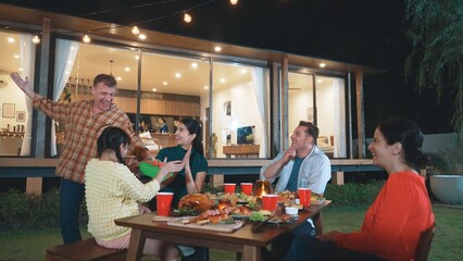 Family together celebrate anniversary in garden. Senior give gift to granddaughter. Outdoor camping activity to relax with relatives, spend time with multigeneration cross generation gap. Divergence.