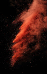 red and brown color powder dispersion, diagonally in black background
