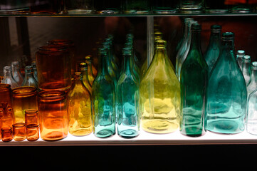 a collection of colorful glass bottles and jars arranged on a shelf