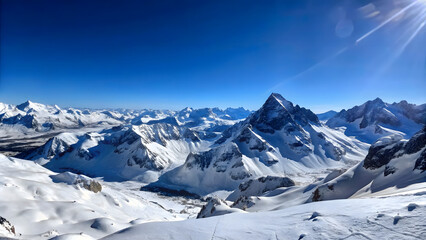 Obraz premium A panoramic view of a snowy mountain range under a clear blue sky