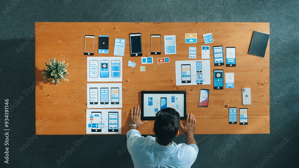 Wall mural top view of skilled developer walking and placing ux ui software. smart business man put tablet on m