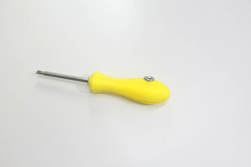 Yellow handled steel screwdriver placed on a white background.