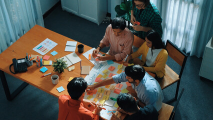 Top view of business people hands making scrum task board to manage workflow in workplace. Diverse...